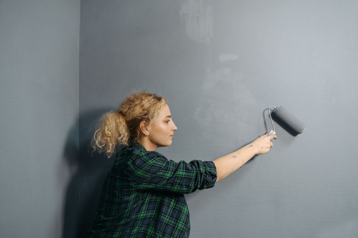 Pintor a aplicar tinta numa parede exterior em Lisboa