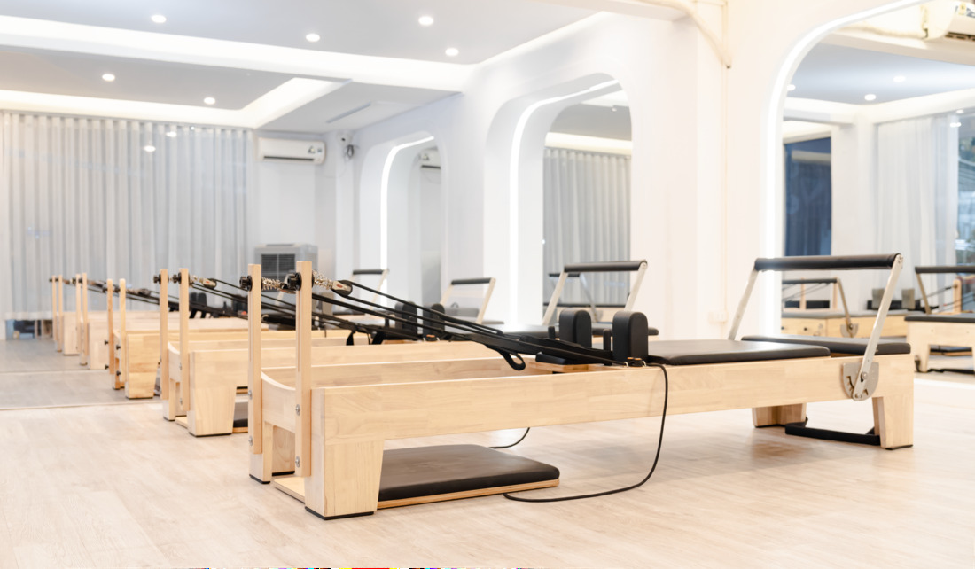 Instrutora a acompanhar aluna numa máquina reformer num estúdio de pilates em Lisboa